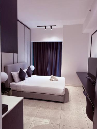 a white bedroom with a bed and a television at Axon Suite Bukit Bintang By Luna in Kuala Lumpur