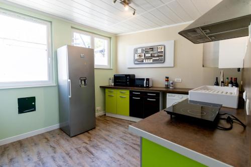 une cuisine avec un réfrigérateur et un plan de travail dans l'établissement Maison de ville au cœur de Saint Pierre en Auge, à Saint-Pierre-sur-Dives