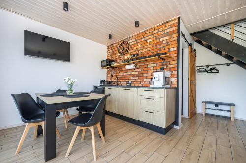 a kitchen and dining room with a table and chairs at Porzeczkowe domki in Darłowo