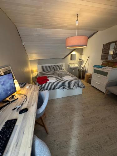 une chambre avec un lit et un bureau avec un ordinateur dans l'établissement Maison calme bord de mer 150m, à Saint-Lunaire