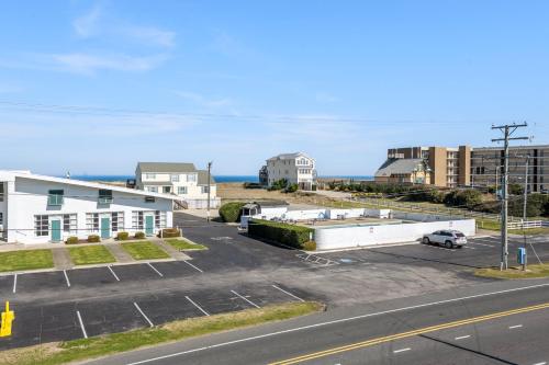 an aerial view of a parking lot with buildings and the ocean at Coasties Ocean Breeze in Kill Devil Hills