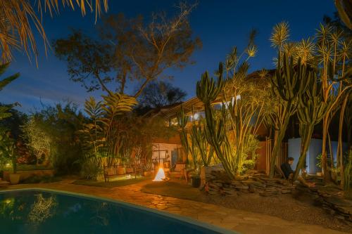 a house with a swimming pool at night at Pousada Maya in Alto Paraíso de Goiás