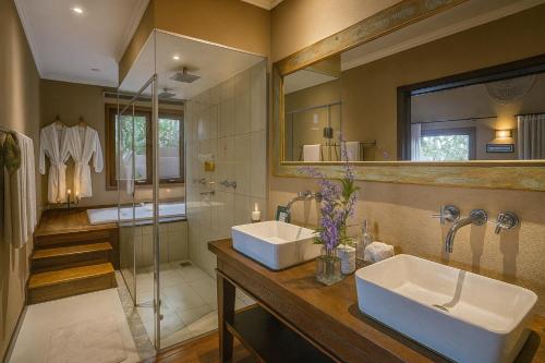 a bathroom with two sinks and a glass shower at Pousada Maya in Alto Paraíso de Goiás