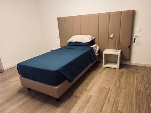 a bedroom with a bed and a lamp on a wooden floor at Residenza esclusiva appena costruita in Imola