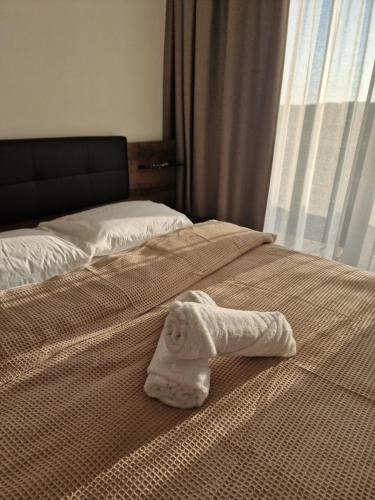 a white towel on a bed with a window at Seaside-Lithuania in Palanga