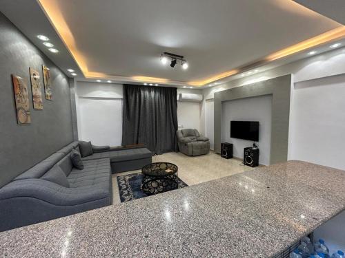 a living room with a couch and a tv at Chalet Amexico Paradise - Ain Sokhna familys only in Az Za‘farānah