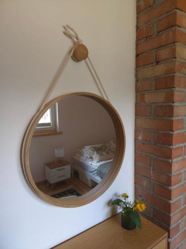 a mirror hanging on a wall in a bedroom at ChillForest SPA in Tomczyn
