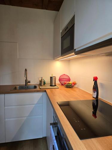 a kitchen with white cabinets and a sink at ChillForest SPA in Tomczyn