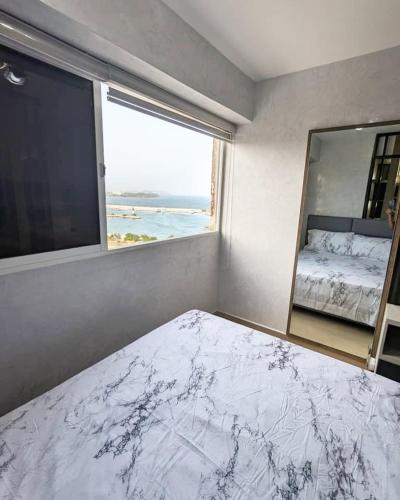 a bedroom with a large window and a large bed at Studio with Amazing Beach view in Porlamar