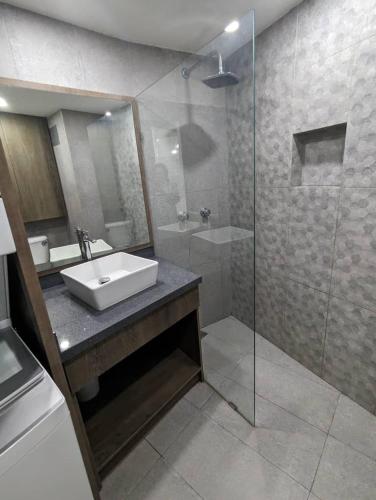 a bathroom with a sink and a glass shower at Studio with Amazing Beach view in Porlamar