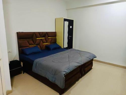 インドールにあるAbhi Home Stayの青い枕が付いた大きなベッドのある寝室