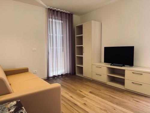 a living room with a couch and a flat screen tv at Residenza esclusiva appena costruita in Imola