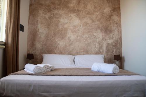 a bedroom with a bed with towels on it at Rifugio sul Mare in San Leone