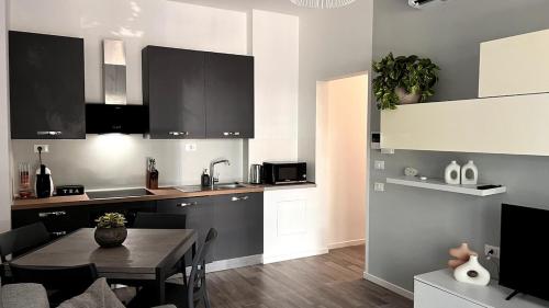 a kitchen with a table and a dining room at Cosy&Chic Le Betulle-Malpensa MXP in Gallarate