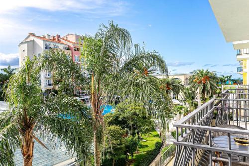 a balcony with palm trees and a pool at Studios frente ao mar no IL Campanario Resort ILCTOP in Florianópolis