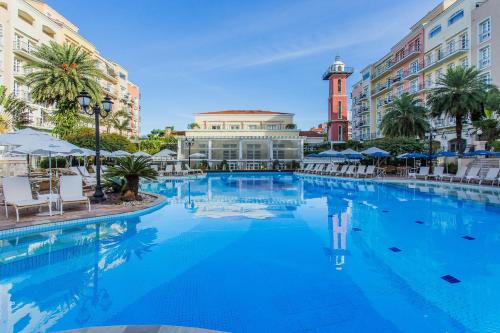 a large swimming pool in a city with buildings at Studios frente ao mar no IL Campanario Resort ILCTOP in Florianópolis