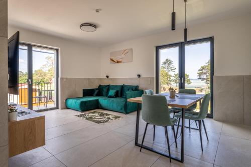 a living room with a green couch and a table at Balaton Flow Residence in Fonyód