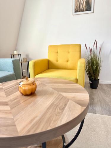 a yellow chair and a table in a living room at Neubauwohnung in Siegen-Zentrum in Siegen