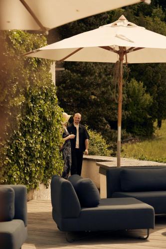 a man and a woman standing under an umbrella at See- und Seminarhotel FloraAlpina Vitznau in Vitznau