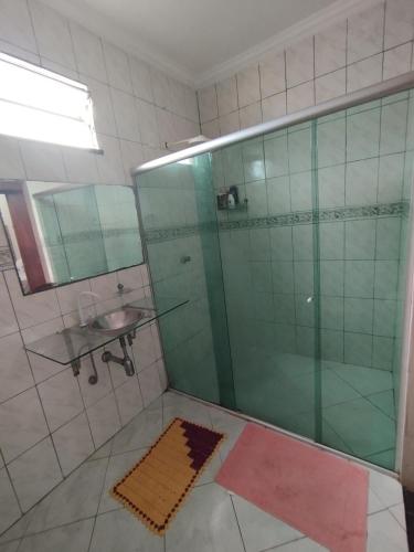 a bathroom with a glass shower and a sink at Quarto Privativo Rains Santos in Belém