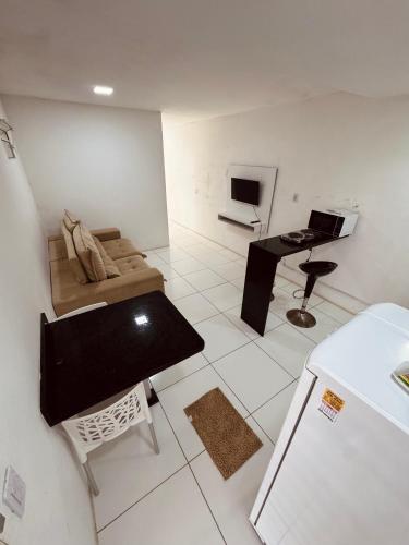a small living room with a couch and a desk at Nox Temporada Flat 201 com AR, a 5 Min da Feira de Caruaru in Caruaru