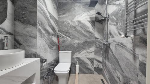 une salle de bain avec des toilettes blanches et un lavabo dans l'établissement ზღვიდან 50 მეტრში ბინა მალო, à Batoumi