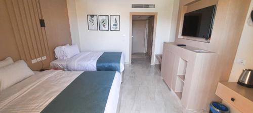 a hotel room with two beds and a flat screen tv at فندق أورو بلازا ORO Plaza Hotel in Cairo