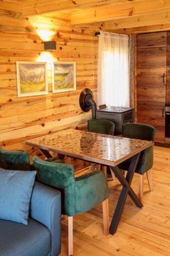 a dining room with a table and green chairs at Borje Mountain Chalet near Durmitor & Žabljak in Borje