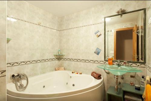 ein Badezimmer mit einer Badewanne und einem Waschbecken in der Unterkunft Altavista Apartment in Raxo