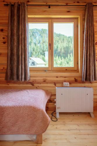 a bedroom with a bed and a window at Borje Mountain Chalet near Durmitor & Žabljak in Borje
