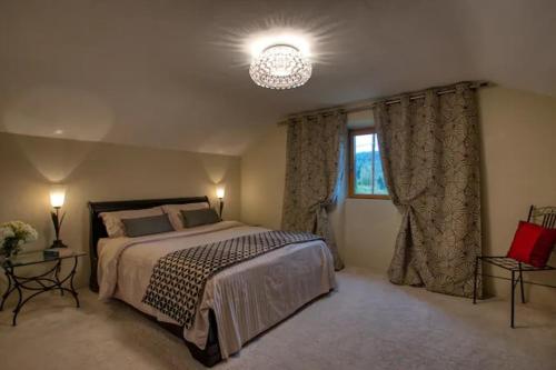 a bedroom with a large bed and a window at Le Cottage dans la Vallée des 5 châteaux in Vézac