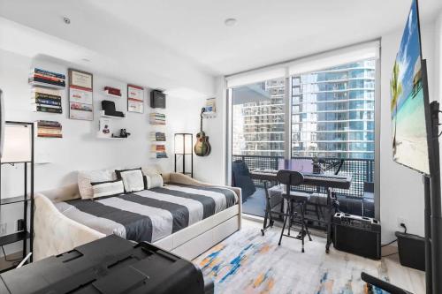 a bedroom with a bed and a table with a desk at Brickell LuxePad 1BED 1BATH with Pool, Gym, Sauna, Grills, Cinema Projector in Miami