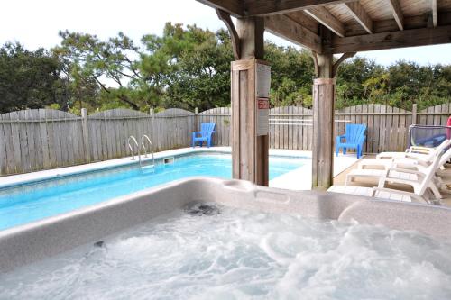 a swimming pool with a jacuzzi in a backyard at Curlews Call in Nags Head