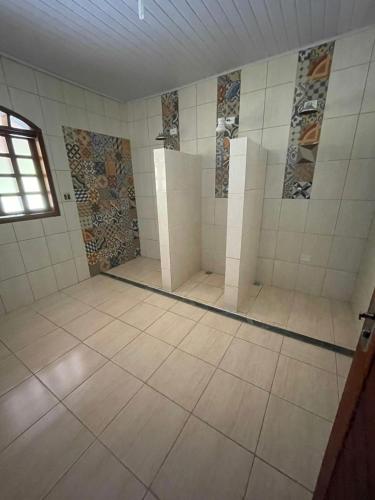 a large bathroom with tiles on the walls and a window at Chácara Curuco in Mairinque