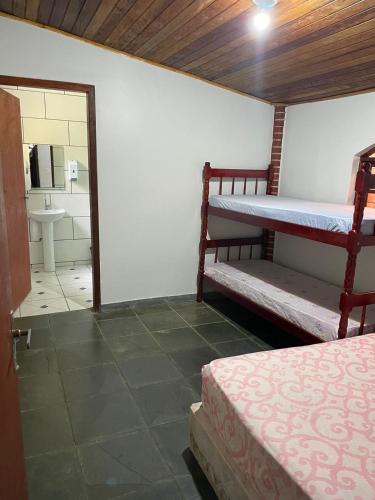a room with two bunk beds and a bathroom at Chácara Curuco in Mairinque