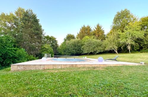 une piscine au milieu d'une pelouse dans l'établissement Belle maison ancienne en Perigord avec piscine, à Rouffignac-Saint-Cernin-de-Reilhac