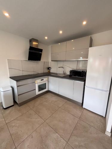 a kitchen with white cabinets and a stove top oven at Appartement 3 pièces à 5 min de la plage in La Seyne-sur-Mer