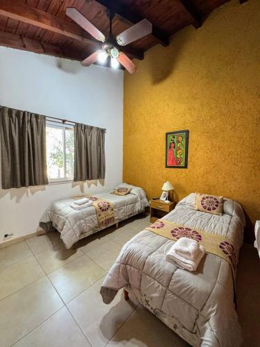 a bedroom with two beds and a ceiling fan at Departamento duplex Champaqui in Villa General Belgrano