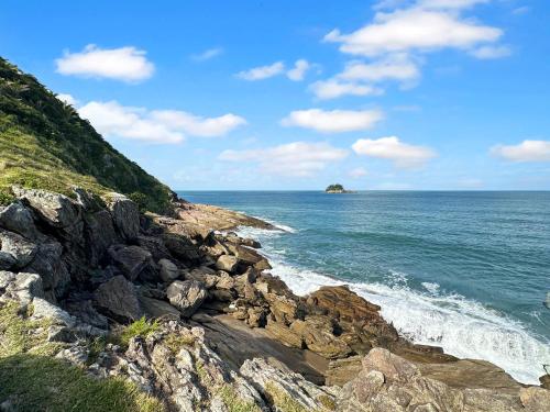 a view of the ocean from a rocky beach at 2 quartos - 200m do mar - Jacuzzi - AC - Churrasqueira in Guarujá