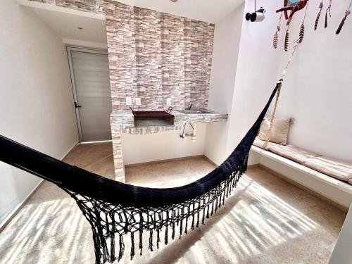 a hammock in a room with a stone wall at Penthouse cerca de la playa in Tulum