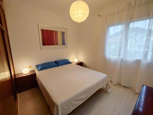 a bedroom with a white bed and a window at Apartamento Celine in Pineda de Mar