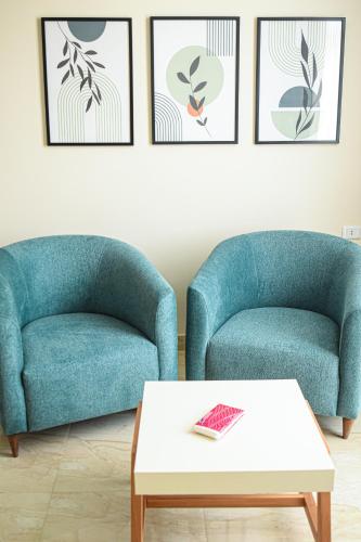 two blue chairs and a coffee table in a living room at فندق أورو بلازا ORO Plaza Hotel in Cairo