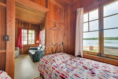 a bedroom with a bed and a couch and a window at Les Cheneaux Islands Retreat 2 Boat, Fish and Swim in Cedarville