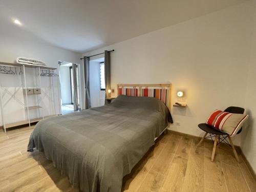 a bedroom with a large bed and a chair at Maison heia in Sare