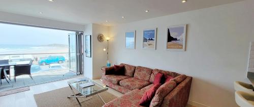 a living room with a couch and a table at 4 Fistral Beach Apartments, Newquay, TR7 1FR in Crantock