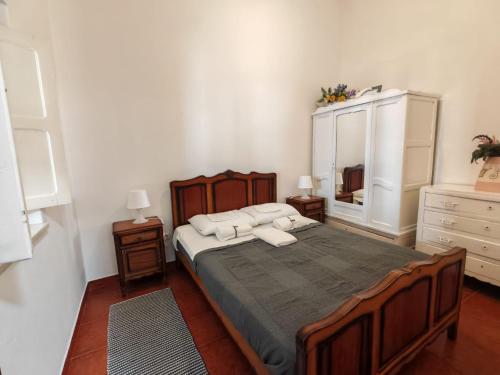 a bedroom with a large bed and a mirror at apartamentos jardim in Vila Nova de Milfontes