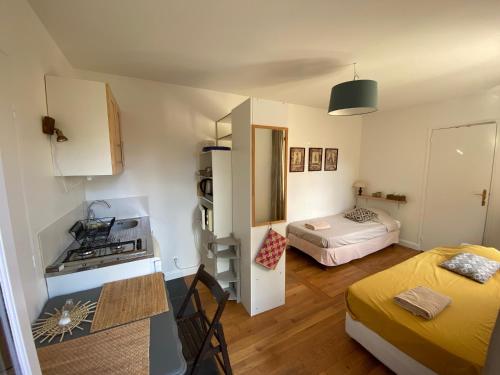 une petite chambre avec deux lits et une cuisine dans l'établissement ideally located next to castle park, à Saint-Cyr-lʼÉcole