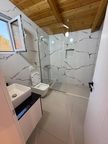 a white bathroom with a sink and a toilet at Amazing View Apartments at Kroi i Gjine, Piqeras in Piqeras