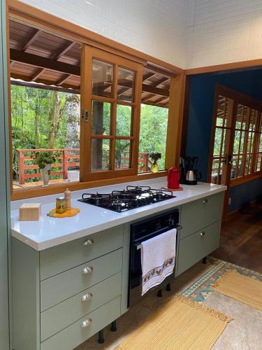 a kitchen with a stove top oven in a room at Yellow House Santa Clara in Bocaina de Minas