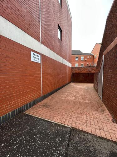 an empty brick alley with a sign on the side of a brick building at The Belfast Snug in Belfast